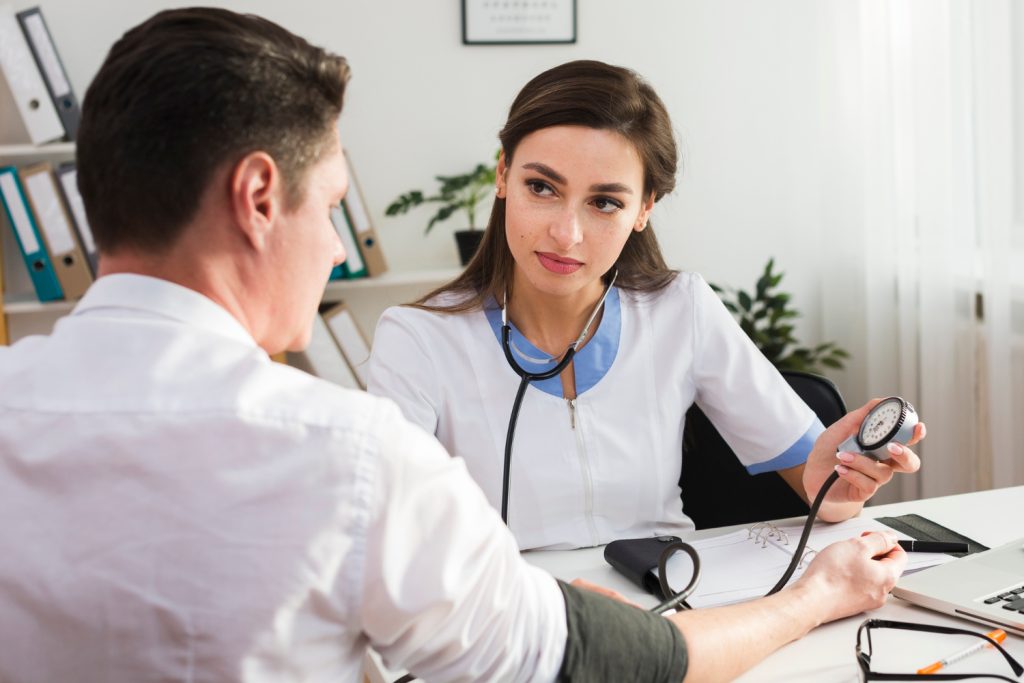 Doctor consulting patient during routine health screening appointment
