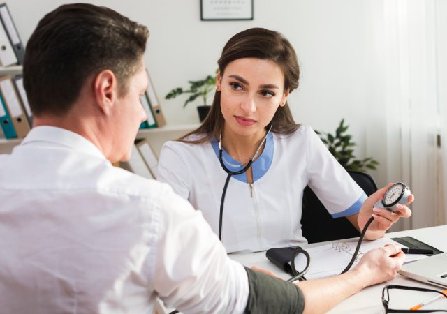 Doctor consulting patient during routine health screening appointment