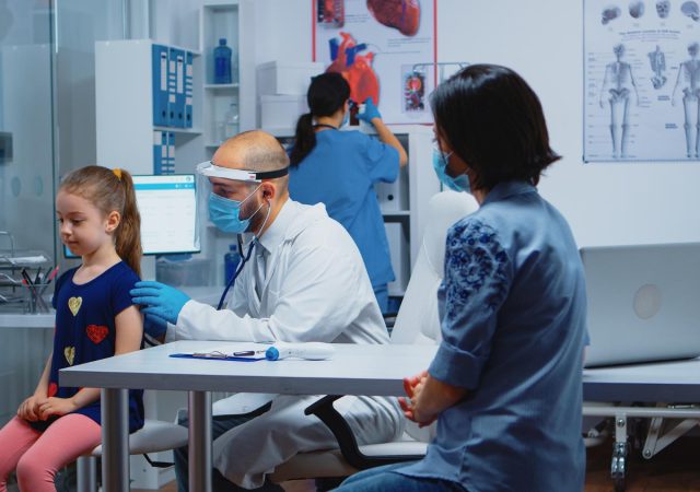 Pediatric doctor examining a child during a clinic visit