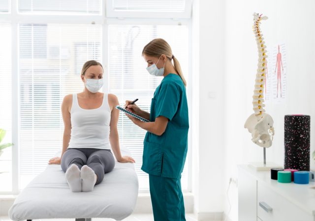 Physiotherapist helping patient with back problems