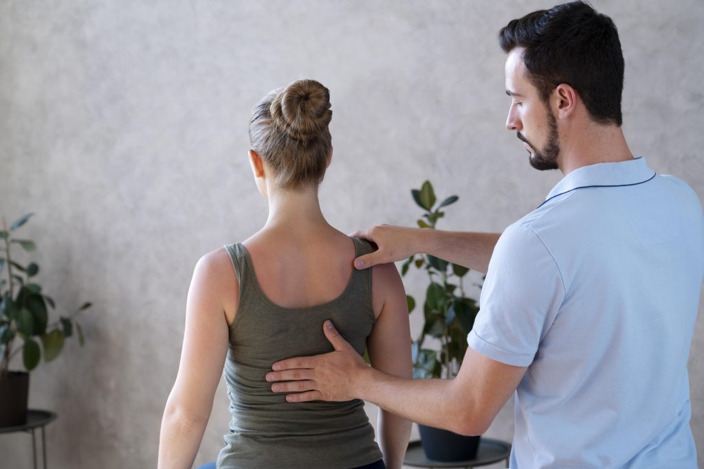 Physiotherapist examining patient's back for pain relief